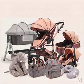 A coordinated baby travel and sleep setup displayed on a light warm neutral background, including a stroller, bassinet, car seat, infant car seat, diaper bags, a plush elephant toy, and a crescent pillow. The stroller and bassinet are blush pink and dark brown, while the car seats and bags are gray and taupe.